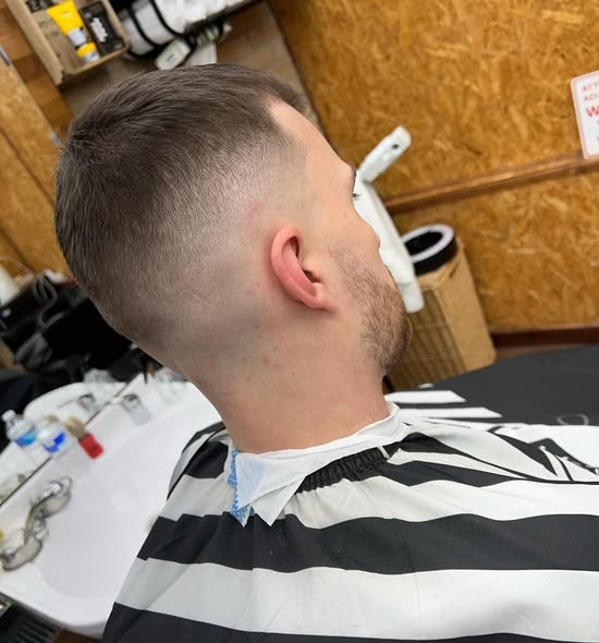 Textured crop with a mid skin fade, seen from behind in the chair